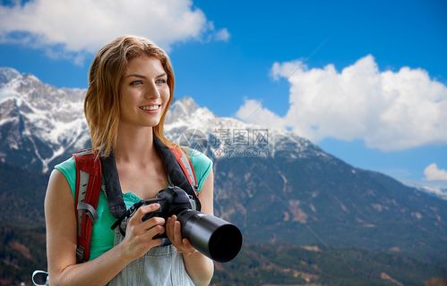 旅行旅游摄影快乐的轻妇女背包相机拍摄阿尔卑斯山背景女人带着背包